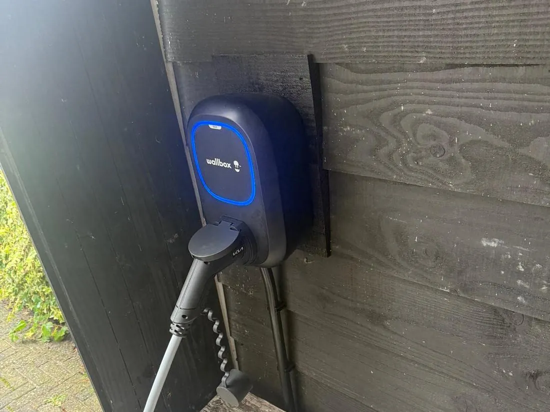 Oplaadpunt op een houten gevel